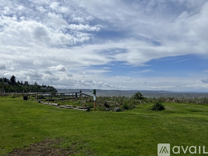 A grassy field with a wooden fence and a sign that reads "AVAIL".
