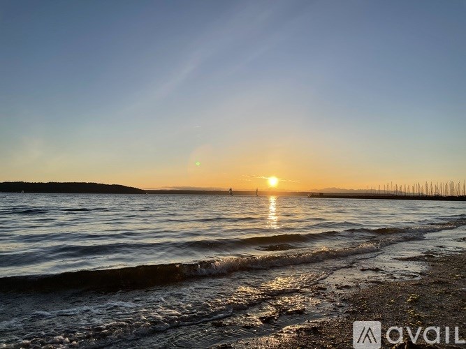 A sunset over the ocean with a beach in the foreground.