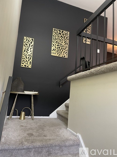 A staircase with a grey carpet and a black metal railing.