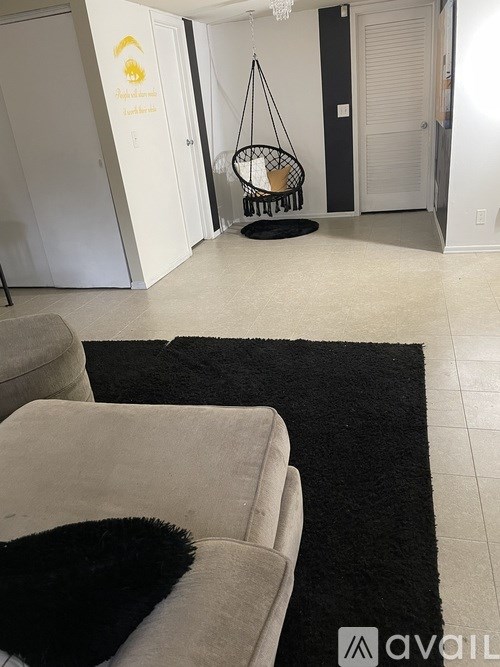 A room with a hanging chair and a couch.