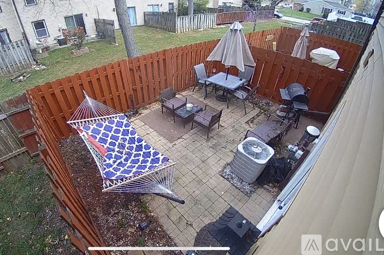 A patio with a table, chairs, and an umbrella.