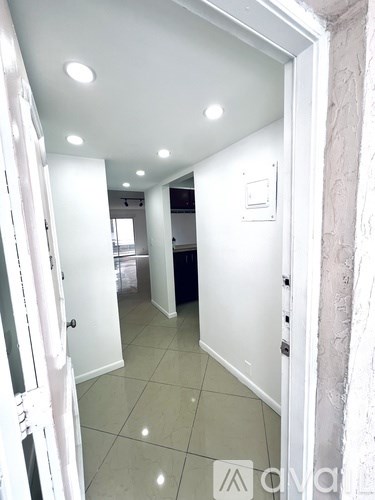 A hallway with white walls and a white door.