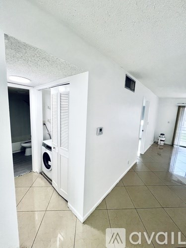 A white room with a washing machine and a dryer in it.