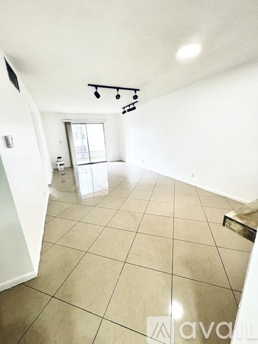 A spacious room with tiled flooring and a window.