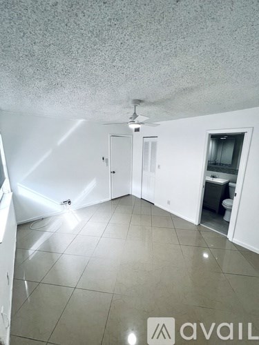A room with a ceiling fan and tile flooring.