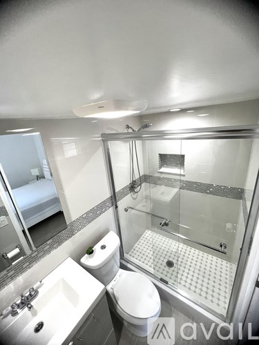 A bathroom with a toilet, sink, and shower.
