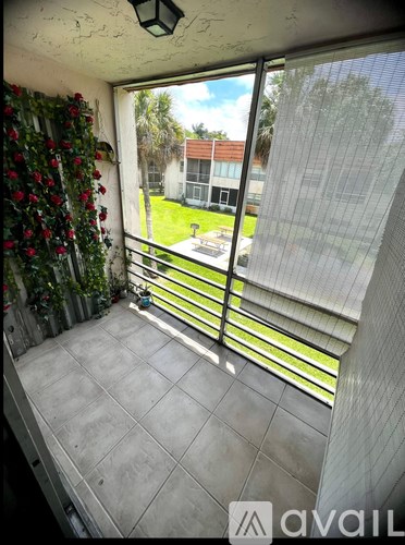 A balcony with a view of a building and trees.