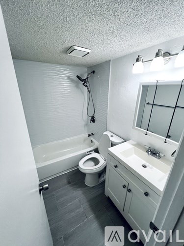 A bathroom with a toilet, sink, and shower.