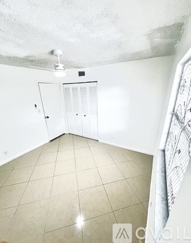 A room with a white ceiling, a white door, and a white cabinet.