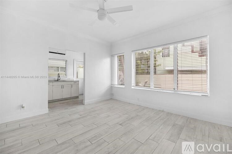 A spacious room with a fan and a window with blinds.