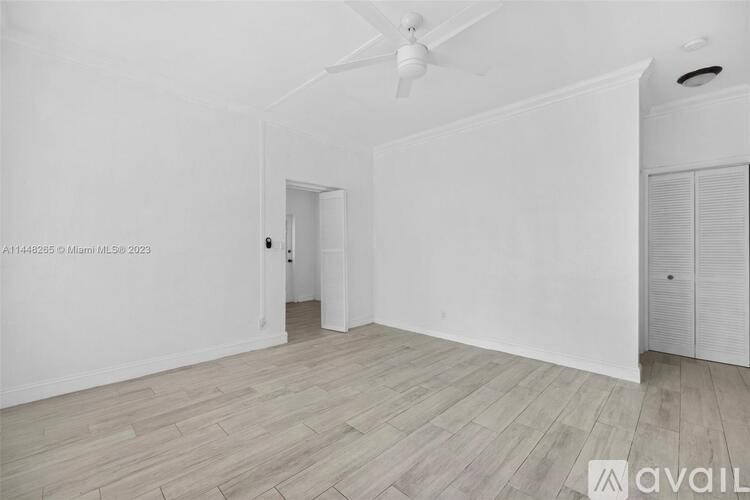 A room with a ceiling fan and wooden flooring.