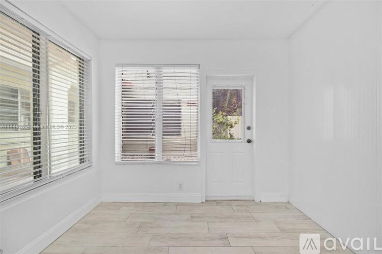 A room with a white door and a window with blinds.
