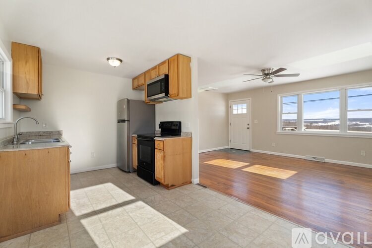 A kitchen with wooden cabinets and a black fridge.