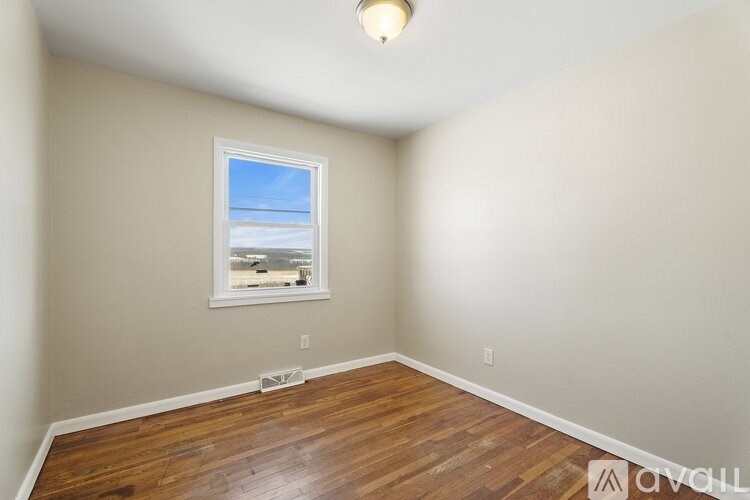 A room with a window and wooden flooring.