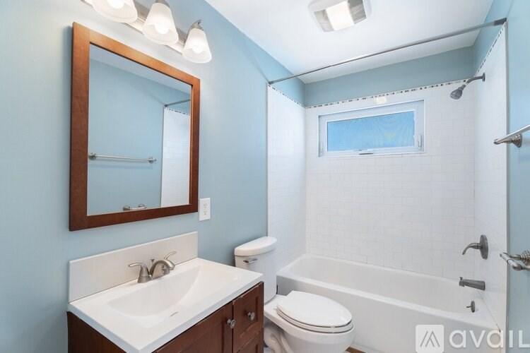 A bathroom with a white sink, toilet, and bathtub.