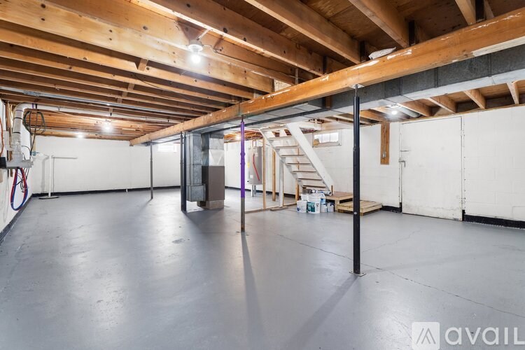 A spacious garage with a wooden ceiling and a basketball hoop.