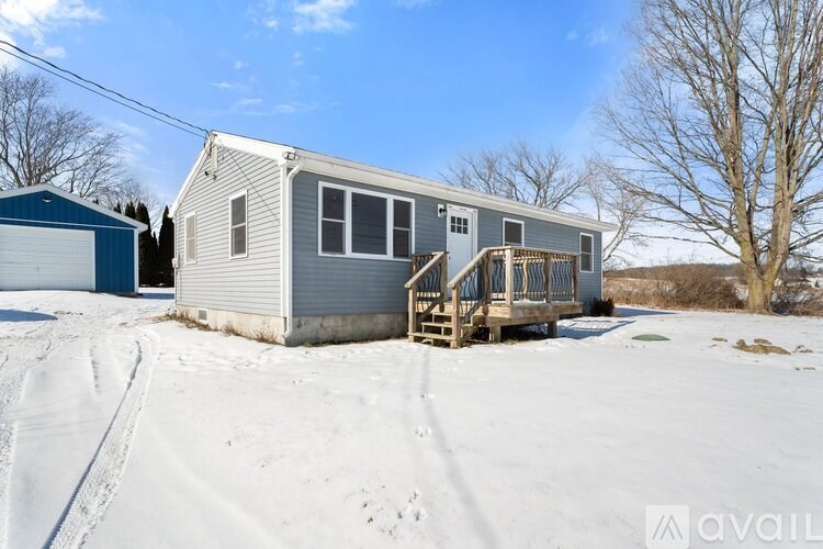 A house with a garage and a deck in the snow.