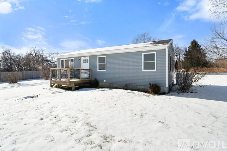 A mobile home sits in a snowy field.