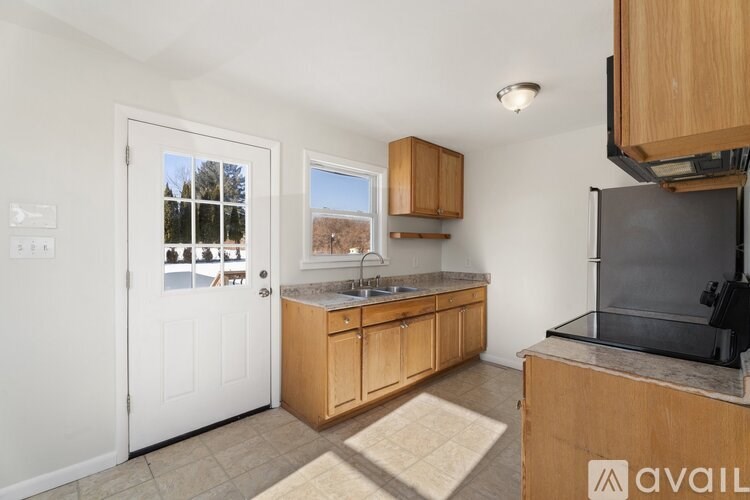 A kitchen with wooden cabinets and a black fridge.