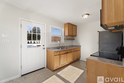 A kitchen with wooden cabinets and a black fridge.
