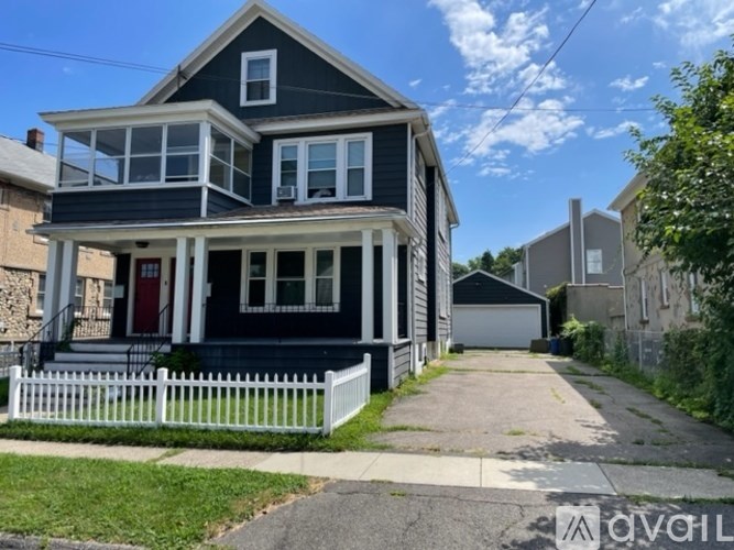 A two-story house with a red door and white picket fence.