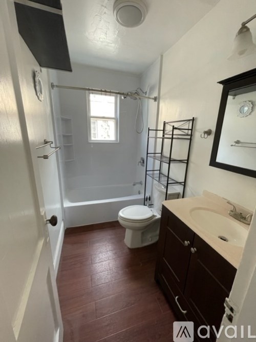 A bathroom with a toilet, sink, and walk-in shower.
