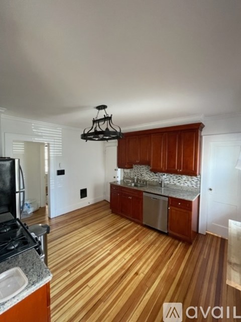 A kitchen with wooden floors and a black stove top.