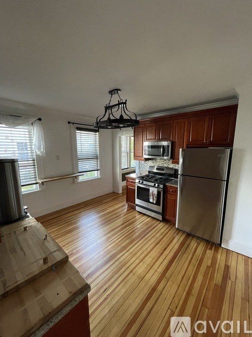 A kitchen with wooden floors and stainless steel appliances.