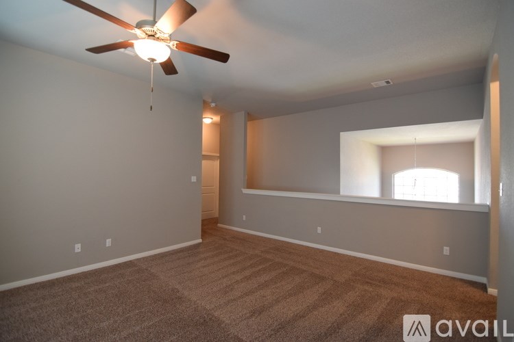 A room with a ceiling fan and carpeted floor.