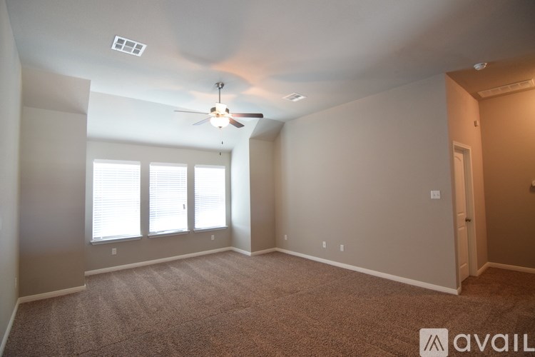 A room with a ceiling fan and carpeted floor.
