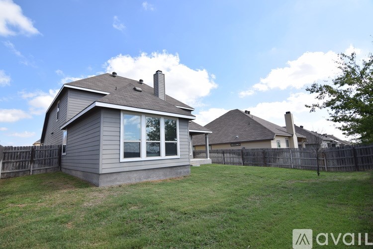 A house with a grey roof and a fence in the background.