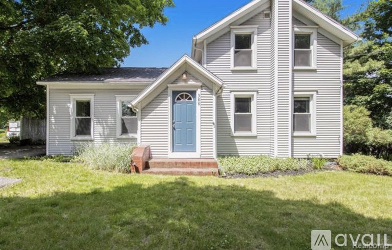 A two-story house with a blue door and white siding.