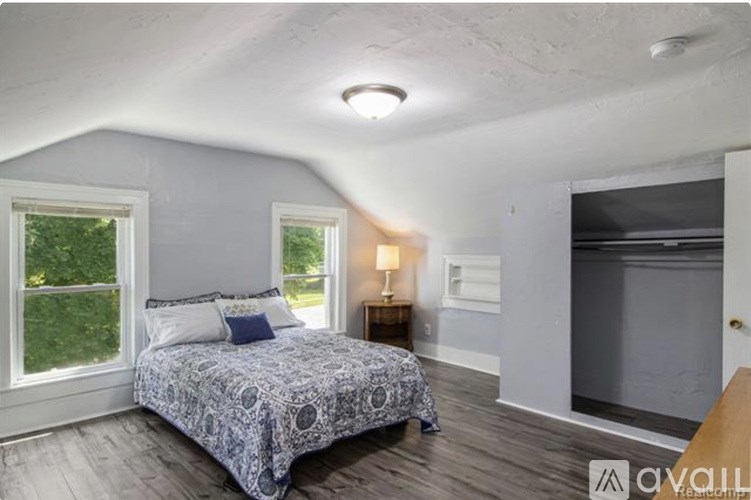 A bedroom with a bed, a window, and a lamp.