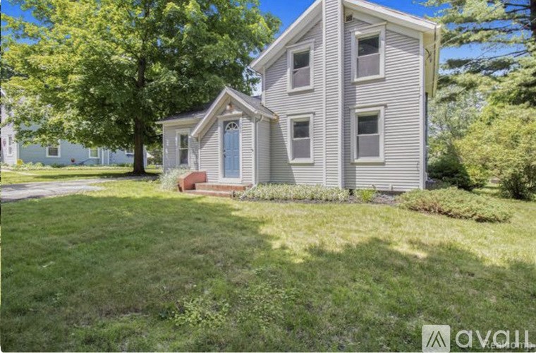 A two-story house with a blue door and a small porch.