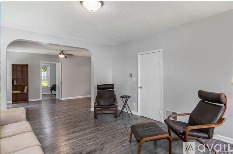 A living room with a chair and a sofa.