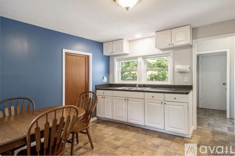 A kitchen with a table and chairs in front of a window.