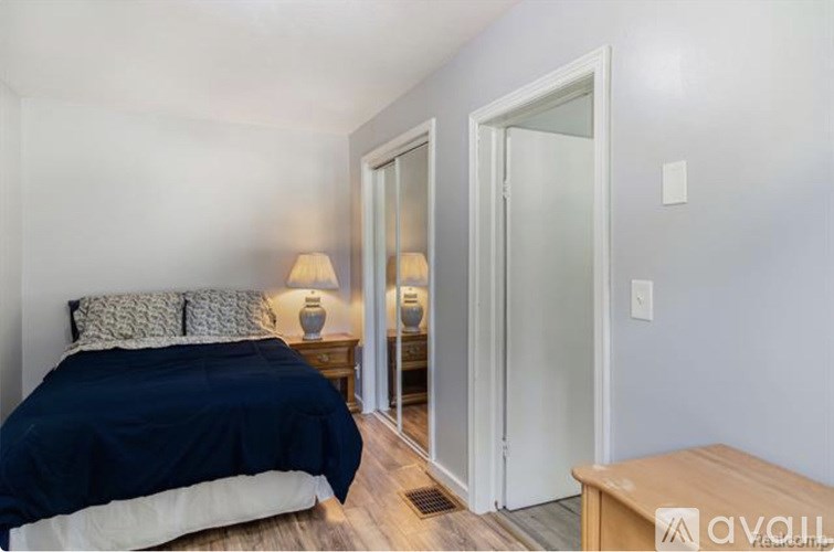 A bedroom with a bed, nightstands, and a wooden bench.