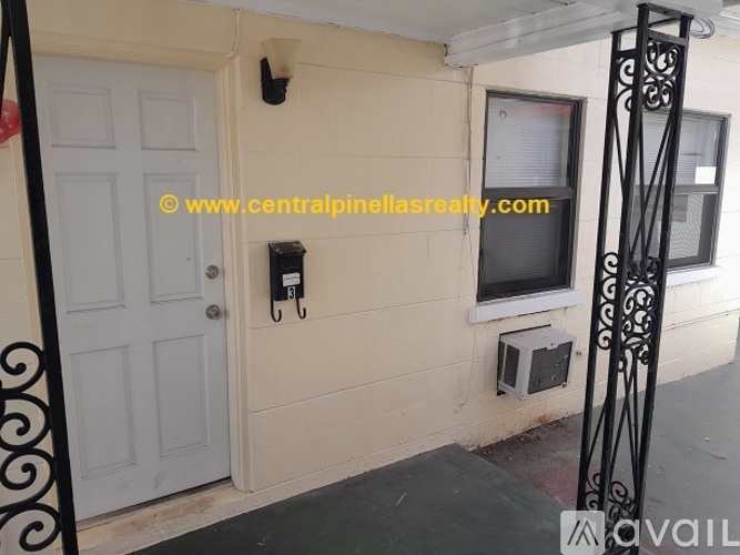 A white door is on the left and a window with a black iron grill is on the right.
