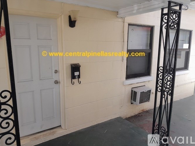 A white door is on the left and a window with a black iron grill is on the right.