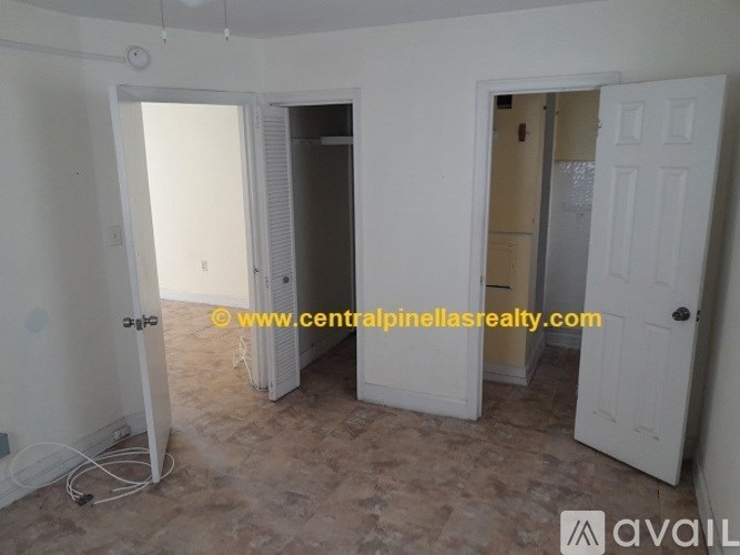 A room with a door on the right and a wall heater on the left.