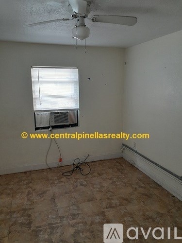 A room with a ceiling fan and a window with blinds.