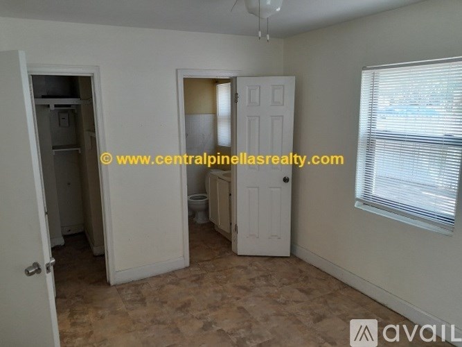 A room with a door and a window with blinds.