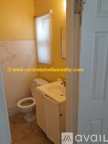 A bathroom with a toilet, sink and a door.