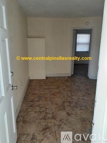 A room with tiled flooring and a door with a handle.