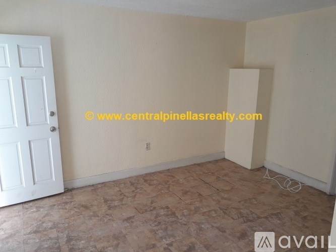 A room with a door and a wall with a light switch.