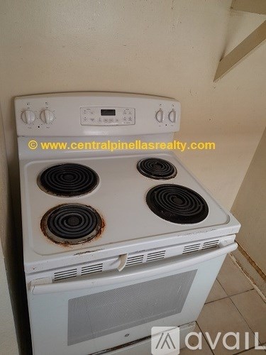 A white stove top oven with four burners and a control panel.