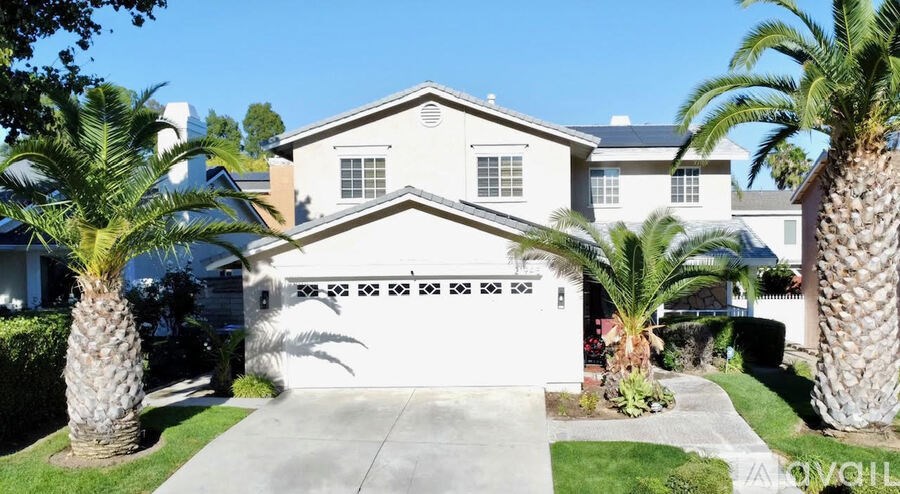 A white house with a black car parked in front.