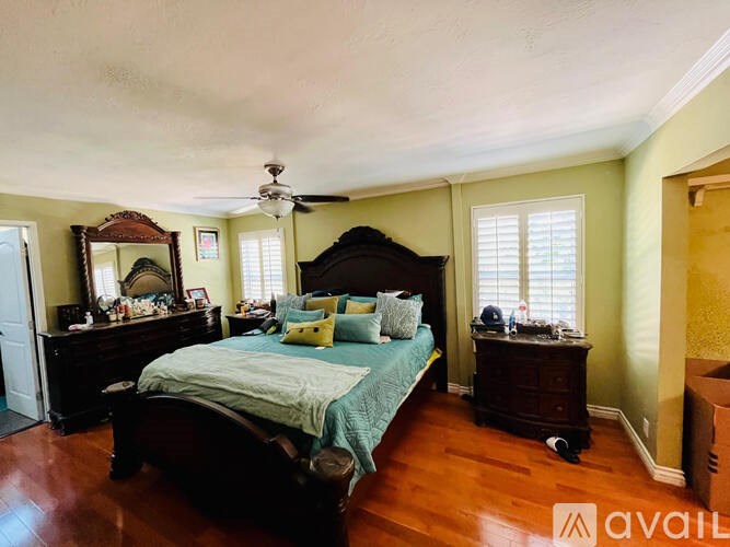 A bedroom with a large bed and a dresser.