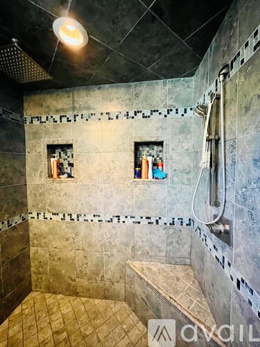 A bathroom with a shower and a bench.