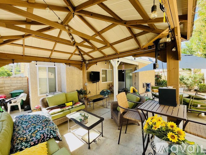 A patio with a table and chairs under a roof.